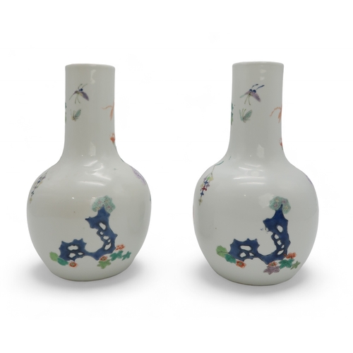 2455 - A PAIR OF CHINESE FAMILLE ROSE BALUSTER SHAPED VASES Painted with peacocks amongst flowering branche... 