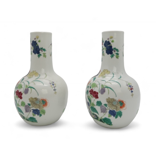 2455 - A PAIR OF CHINESE FAMILLE ROSE BALUSTER SHAPED VASES Painted with peacocks amongst flowering branche... 