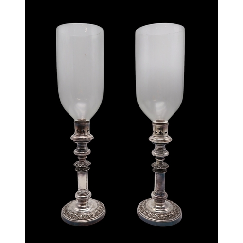 2537 - A PAIR OF SILVER PLATED HURRICANE LAMPSof cylindrical form, with cast foliate banding, with a knoppe... 