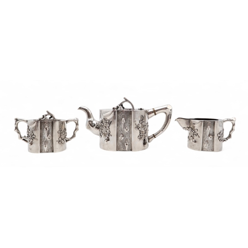 2538 - A CHINESE EXPORT THREE PIECE SILVER TEA SERVICEnaturalistically modelled, inspired by Yixing stonewa... 