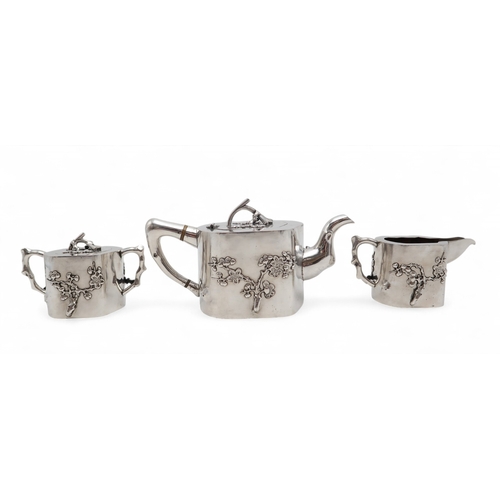 2538 - A CHINESE EXPORT THREE PIECE SILVER TEA SERVICEnaturalistically modelled, inspired by Yixing stonewa... 