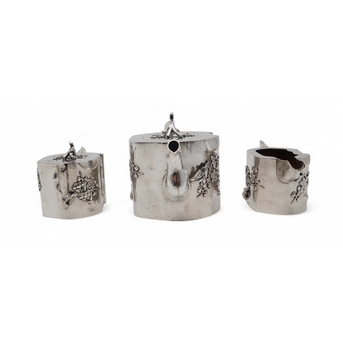 2538 - A CHINESE EXPORT THREE PIECE SILVER TEA SERVICEnaturalistically modelled, inspired by Yixing stonewa... 