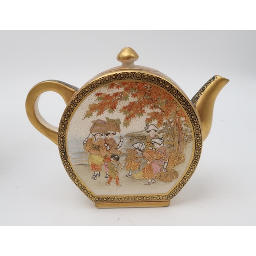 2415 - A KUTANI STYLE TEA KETTLE Painted with dancing figures on a red ground surrounded by demonic masks, ... 