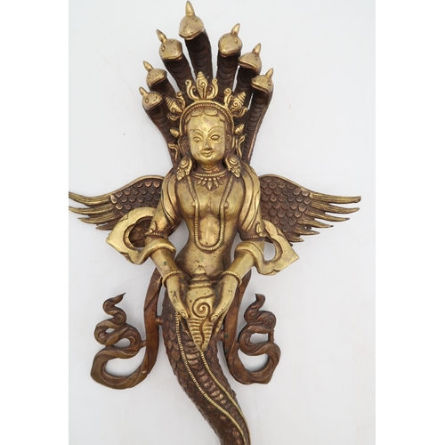 2452 - A BRASS NAAG KANYA WALL HANGING The snake Goddess holding a conch shell, 37cm high... 