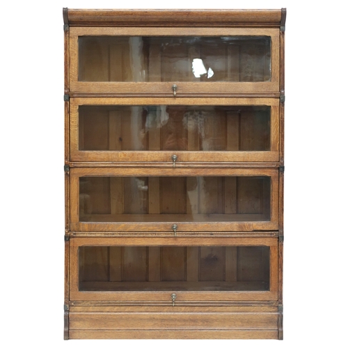 2026 - AN EARLY 20TH CENTURY OAK FOUR TIER SECTIONAL BOOKCASE with four glazed fall front slide back d... 