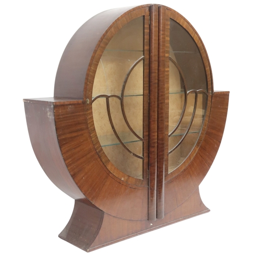 2028 - AN ART DECO  MAHOGANY VENEERED  CIRCULAR DISPLAY CABINET with pair of half crescent glazed doors on ... 