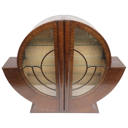 2028 - AN ART DECO  MAHOGANY VENEERED  CIRCULAR DISPLAY CABINET with pair of half crescent glazed doors on ... 