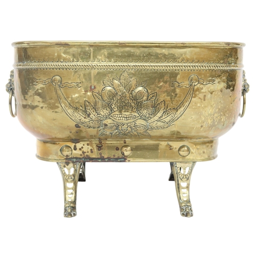 2037 - A VICTORIAN BRASS OBLONG PLANTER embossed with armorial shield and floral motifs with lion masq... 