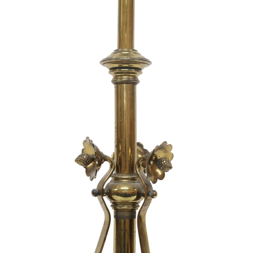 2054 - AN ARTS AND CRAFTS BRASS  TELESCOPIC STANDARD LAMP with tripod base decorated with scrolls and twist... 