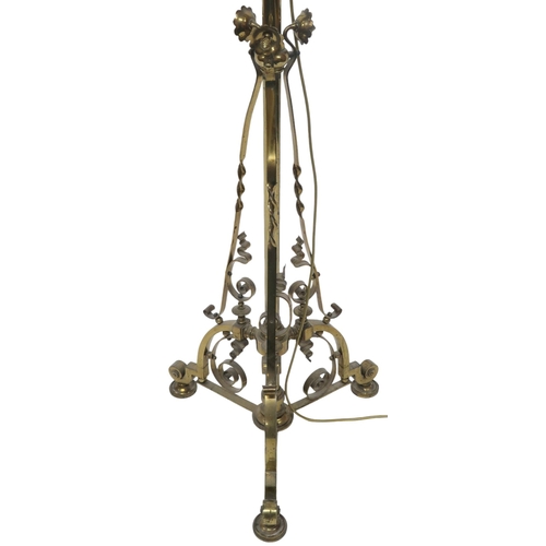 2054 - AN ARTS AND CRAFTS BRASS  TELESCOPIC STANDARD LAMP with tripod base decorated with scrolls and twist... 