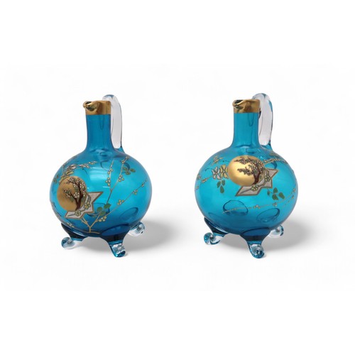 2216 - EUGENE ROUSSEAU FOR BACCARAT A pair of blue crystal Clare de Lune liquor jugs each decorated in enam... 