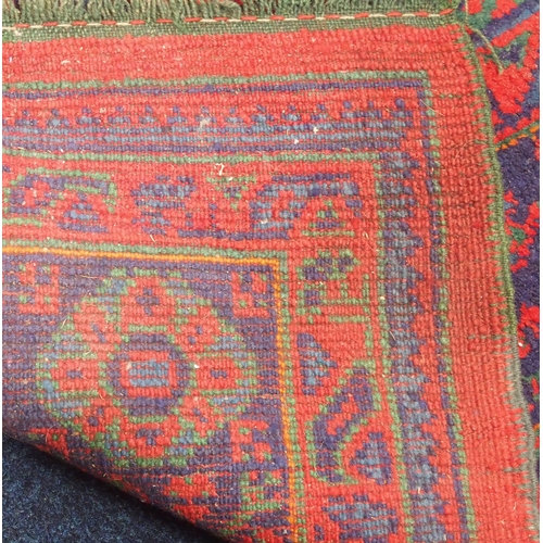 48 - A red ground Ushak rug with dark blue decorated ground within dark blue geometric border, 290cm long... 