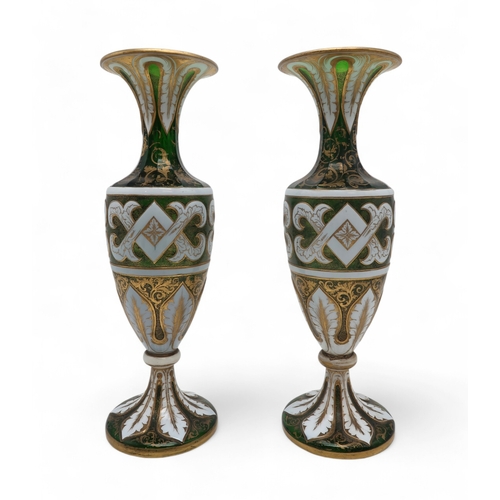 2263 - A PAIR OF BOHEMIAN WHITE OVERLAY GREEN GLASS VASESof typical urn shape, with painted gilt scrolling ... 