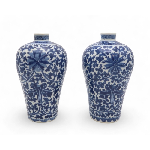 2463 - A PAIR OF CHINESE BLUE AND WHITE BALUSTER VASES Painted with lotus flowers and leaves, beneath a den... 