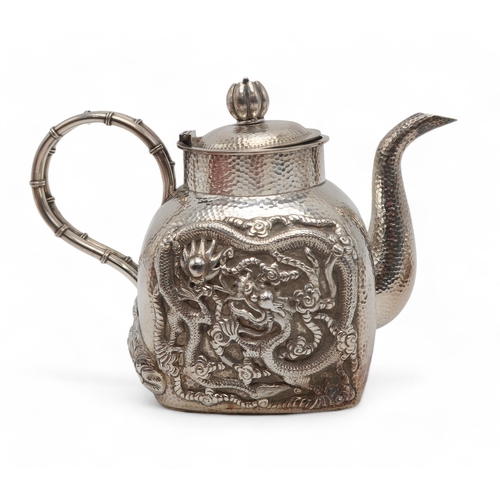 2470 - A JAPANESE SILVER TEA SERVICECast with coiled dragons on a hammered ground, signed, teapot, 13cm hig... 