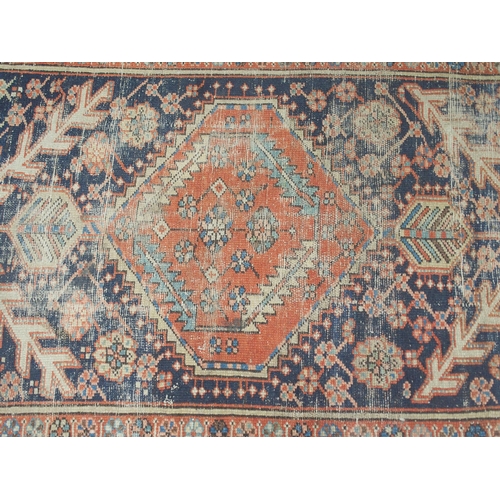 32 - A dark blue ground Hamadan rug with terracotta central medallion and cream spandrels on geometric pa... 