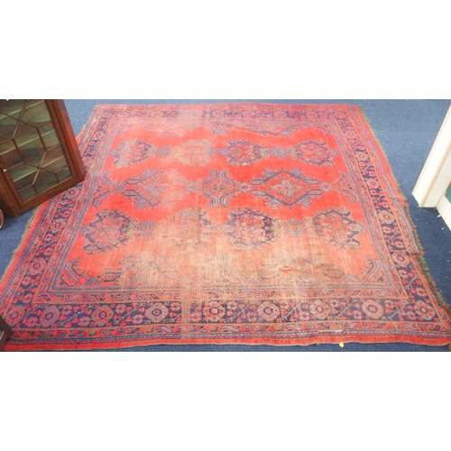 48 - A red ground Ushak rug with dark blue decorated ground within dark blue geometric border, 290cm long... 