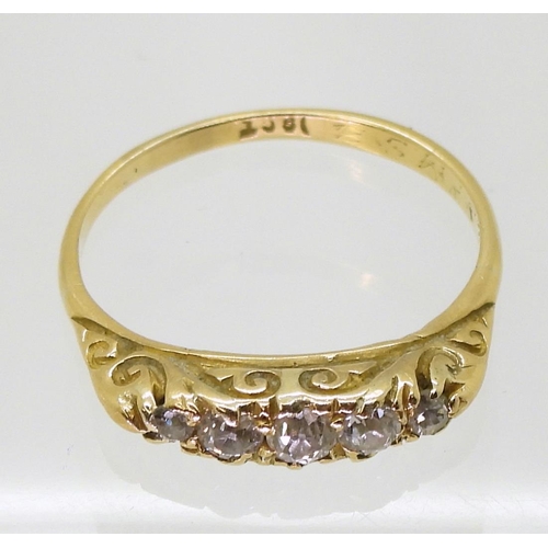 720 - An 18ct gold five stone diamond ring in a scroll mount, set with estimated approx 0.15cts of brillia... 