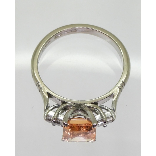 794 - An 18ct white gold baguette cut diamond and peach coloured sapphire ring, finger size N, weight 4.2g... 