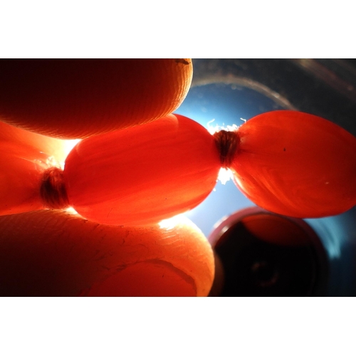 880 - Two strings of cherry amber coloured beads1 (left): weight 89.6gms2 (right): weight 154.5gms... 