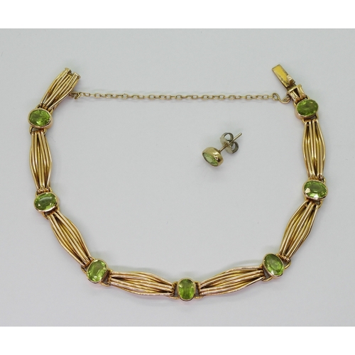 2774 - A 15CT GOLD PERIDOT BRACELETset with seven oval cut peridot of approx 6.5mm x 5mm, interspaced with ... 