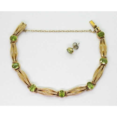 2774 - A 15CT GOLD PERIDOT BRACELETset with seven oval cut peridot of approx 6.5mm x 5mm, interspaced with ... 