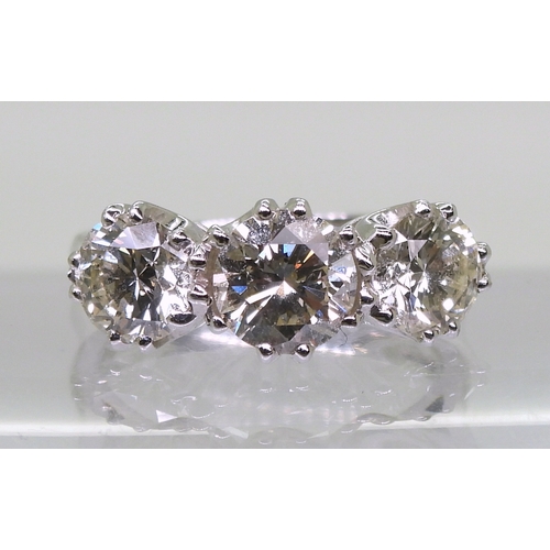 2783 - A SUBSTANTIAL THREE STONEdiamond ring. The classic galleried mount is in 18ct white gold, and set wi... 