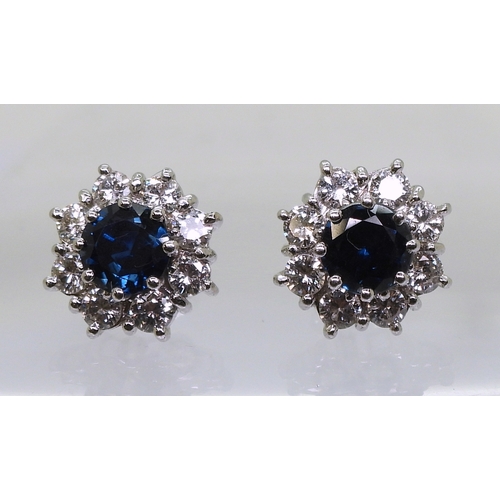 2785 - SAPPHIRE & DIAMOND EARRINGSthe classic flower clusters are set with a 5.5mm round cut sapphire a... 