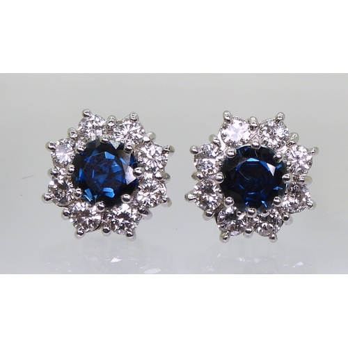 2785 - SAPPHIRE & DIAMOND EARRINGSthe classic flower clusters are set with a 5.5mm round cut sapphire a... 