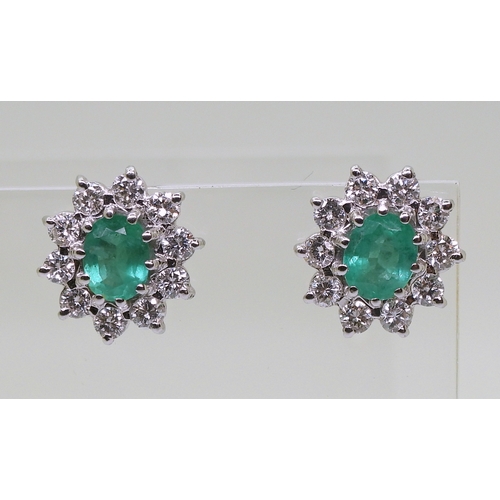 2794 - EMERALD AND DIAMOND EARRINGSin 18ct white gold mounts, the oval emeralds of approx 6mm x 5mm, surrou... 