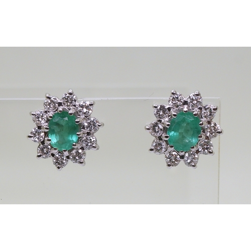 2794 - EMERALD AND DIAMOND EARRINGSin 18ct white gold mounts, the oval emeralds of approx 6mm x 5mm, surrou... 