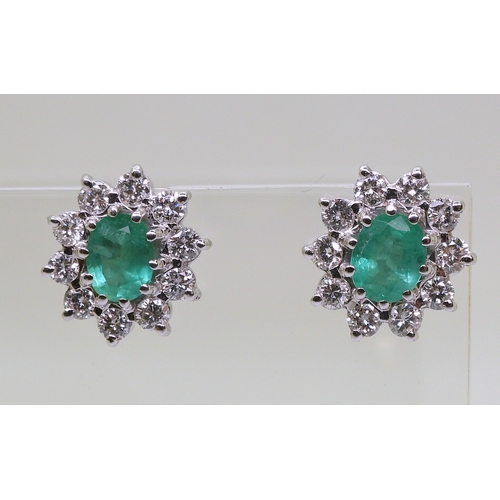 2794 - EMERALD AND DIAMOND EARRINGSin 18ct white gold mounts, the oval emeralds of approx 6mm x 5mm, surrou... 