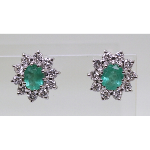 2794 - EMERALD AND DIAMOND EARRINGSin 18ct white gold mounts, the oval emeralds of approx 6mm x 5mm, surrou... 