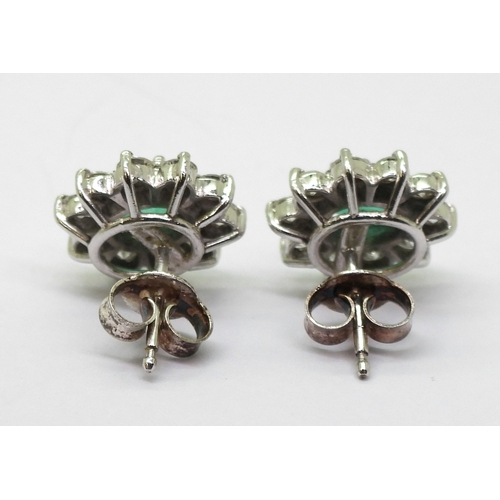 2794 - EMERALD AND DIAMOND EARRINGSin 18ct white gold mounts, the oval emeralds of approx 6mm x 5mm, surrou... 