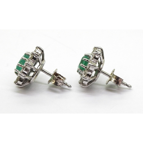 2794 - EMERALD AND DIAMOND EARRINGSin 18ct white gold mounts, the oval emeralds of approx 6mm x 5mm, surrou... 