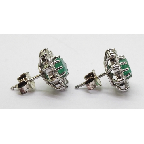 2794 - EMERALD AND DIAMOND EARRINGSin 18ct white gold mounts, the oval emeralds of approx 6mm x 5mm, surrou... 