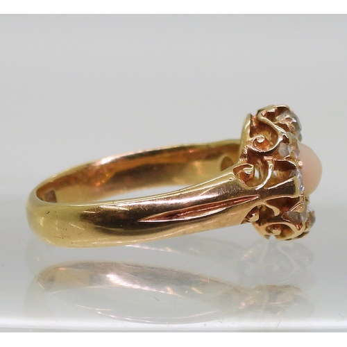 2803 - CORAL & DIAMOND RINGan 18ct gold scrolled mount set with a coral cabochon surrounded with old cu... 