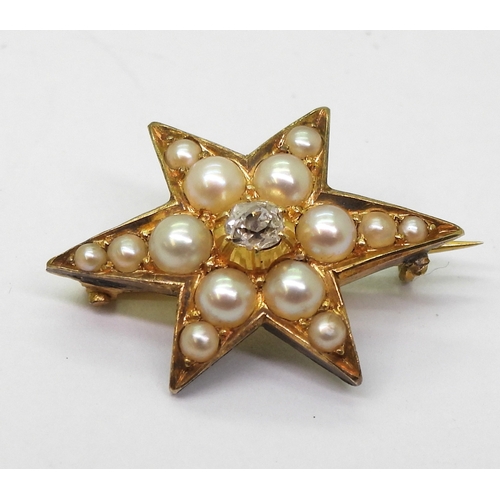 2805 - A STAR BROOCHthe bright yellow metal six pointed star brooch is set with a  central old cut dia... 