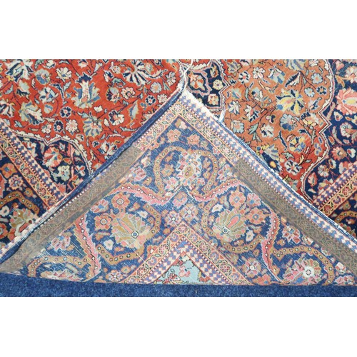 2160 - A RED GROUND FINE PILE ISFAHAN RUG with dark blue and cream central medallion and matching span... 