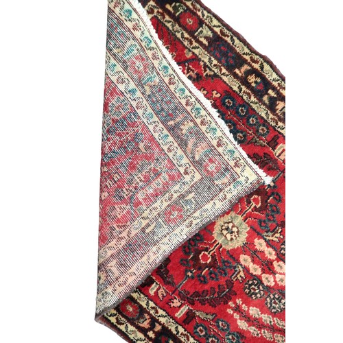 2162 - A RED GROUND IRANIAN KARAJEH RUNNERwith multicoloured geometric floral/foliate patterned ground with... 