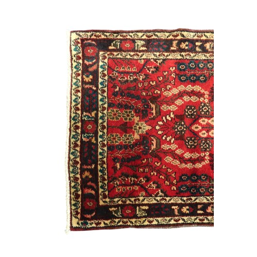 2162 - A RED GROUND IRANIAN KARAJEH RUNNERwith multicoloured geometric floral/foliate patterned ground with... 