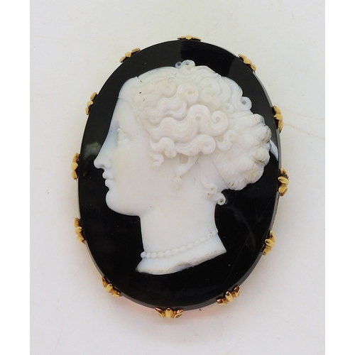 2823 - AN AGATE CAMEOcarved from black and white agate, the detailed cameo of a maiden, is set in a bright ... 