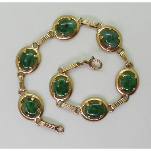 2824 - A HARDSTONE BRACELETmade in 14k gold with oval Chinese green hardstones of approx 9mm x 7mm x1.8mm, ... 