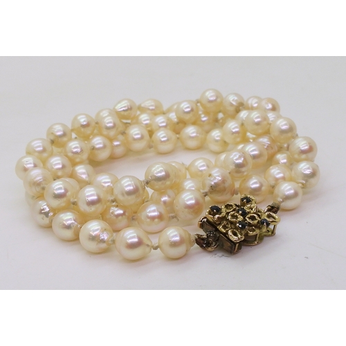 748 - A long string of baroque pearls with a retro yellow metal sapphire set box clasp, each pearl approx ... 