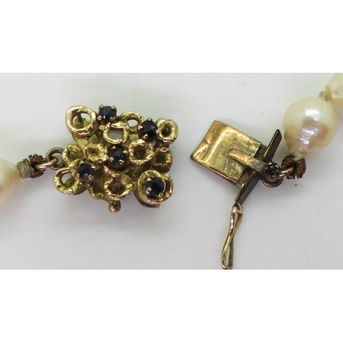 748 - A long string of baroque pearls with a retro yellow metal sapphire set box clasp, each pearl approx ... 