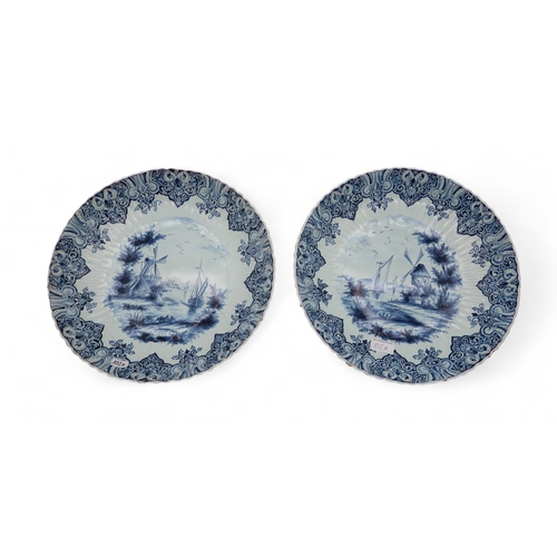 102A - A pair of Delft chargers, each painted with boats on rivers by windmills