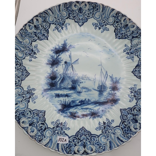 102A - A pair of Delft chargers, each painted with boats on rivers by windmills