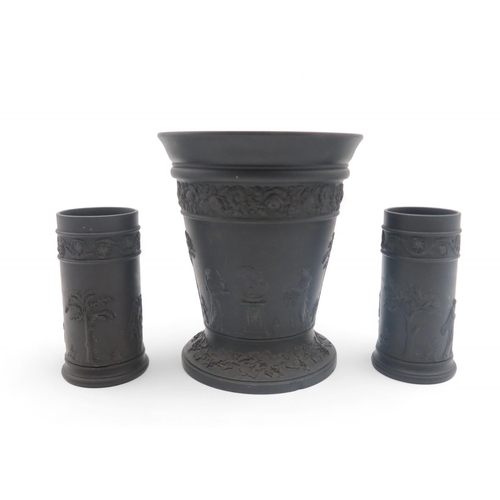 143 - A Wedgwood black basalt vase, together with a pair of matching cylindrical vases