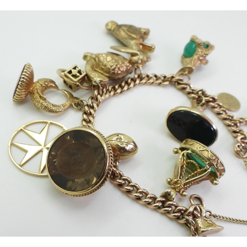 700 - A 9ct gold charm bracelet, with a heart shaped clasp and a 1910 gold half sovereign, with twelve 9ct... 