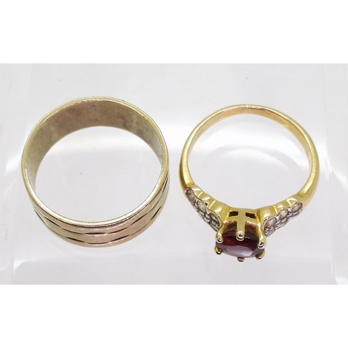 720 - A 14k gold garnet and clear gem set ring, size K, weight 2.6gms, together with a wide 9ct wedding ba... 